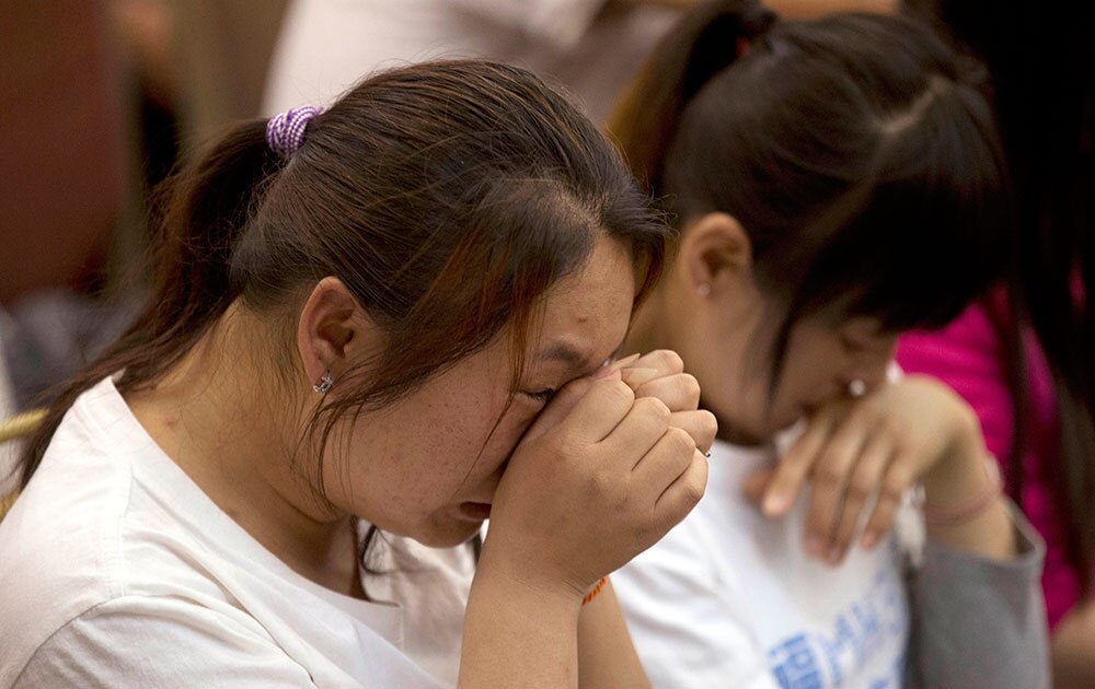 मलेशिया एयरलाइंस के लापता विमान एमएच370 के यात्रियों के शोकाकुल चीनी परिजन।