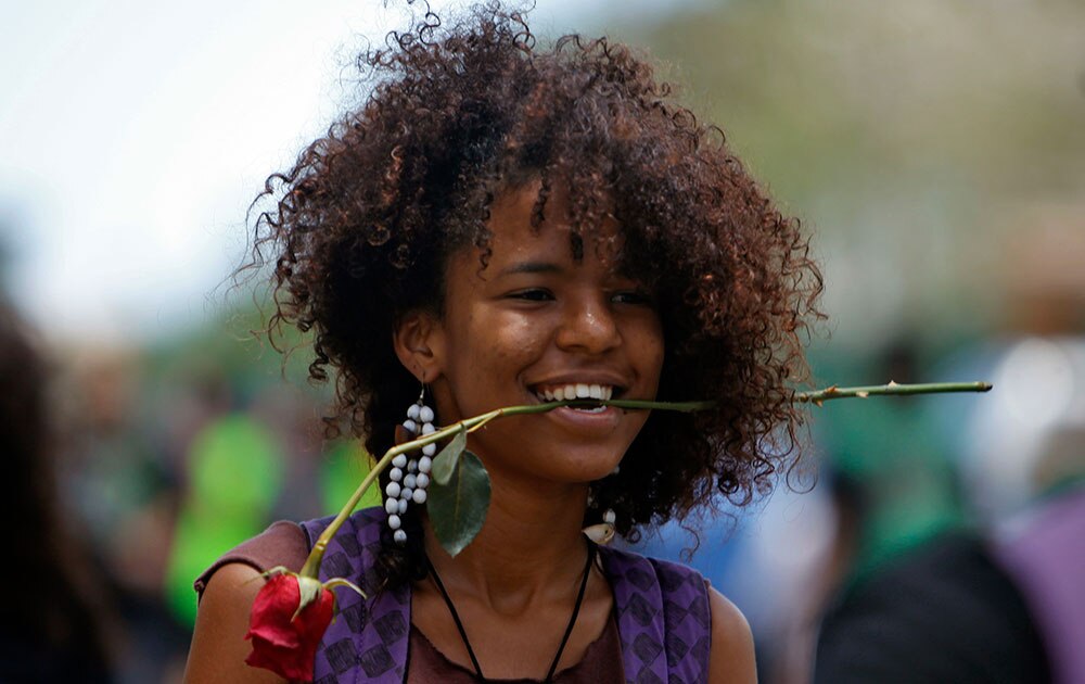 रिको यूनिवर्सिटी की एक छात्रा गुलाब के फूल को दांतों के बीच रखकर प्राइवेट ट्यूशन का विरोध करती हुई।