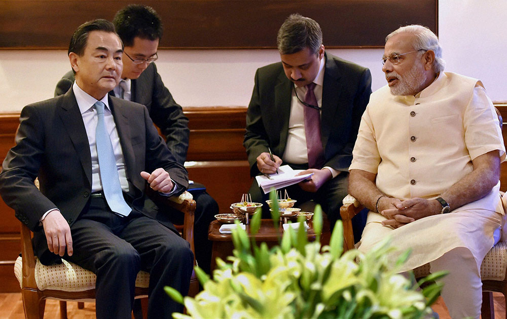 नई दिल्‍ली में चीन के विदेश मंत्री वांग यी के साथ मुलाकात करते हुए भारत के प्रधानमंत्री नरेंद्र मोदी।