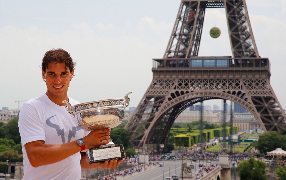 पेरिस में एफिल टॉवर के पास फ्रेंच ओपन टेनिस की विजेता ट्रॉफी के साथ पोज देते हुए स्‍पेन के राफेल नडाल।
