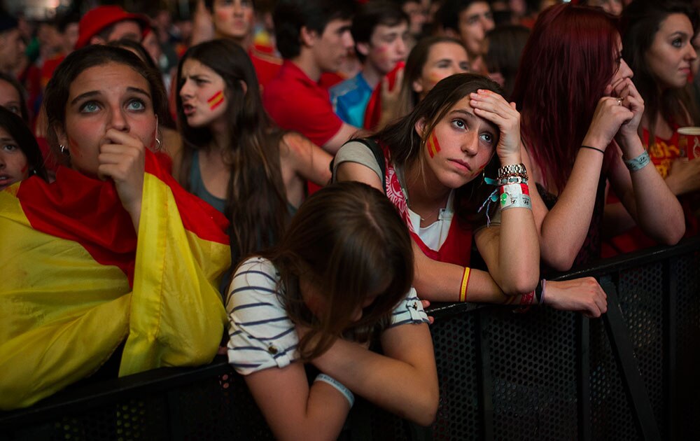 वर्ल्‍ड कप 2014 के तहत स्‍पेन और चिली के बीच खेले गए मुकाबले को एक बड़े स्‍क्रीन पर देखते और प्रतिक्रिया जताते हुए स्‍पेनिश सॉकर फैन्‍स। 