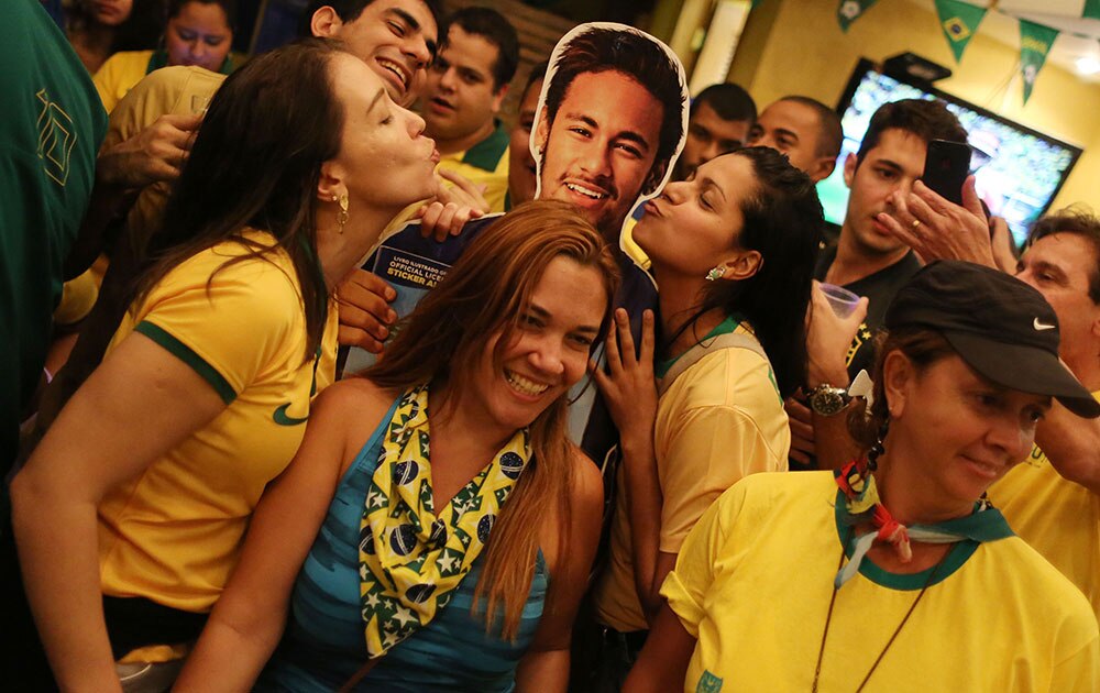 ब्राजील के रियो डी जेनेरियो में कोपाकबाना बीच में फीफा वर्ल्‍ड कप के तहत ब्राजील और कैमरून के बीच खेले गए मैच के बाद स्‍ट्राइकर नेमार की तस्‍वीरों के साथ ब्राजीलियन फैन्‍स।