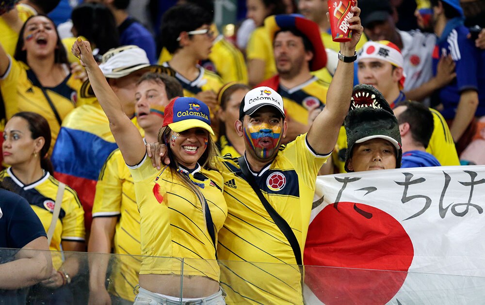 ब्राजील के कूइयाबा में एरेना पेंटेनल में फीफा वर्ल्‍ड कप 2014 के तहत ग्रुप सी में जापान और कोलंबिया के बीच खेले गए मैच के दौरान जश्‍न मनाते हुए कोलंबियन फैन्‍स।