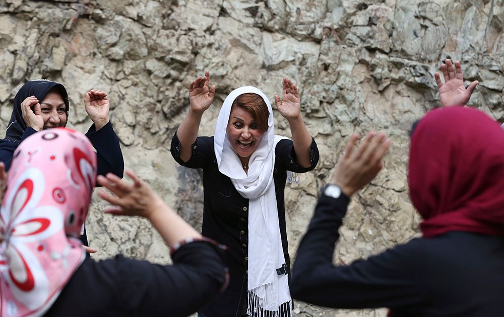 ईरान के तेहरान के निकट दाराकेह माउंटेन एरिया में लाफ्टर योग सत्र में भाग लेती इरानी महिलाओं का एक समूह। 
