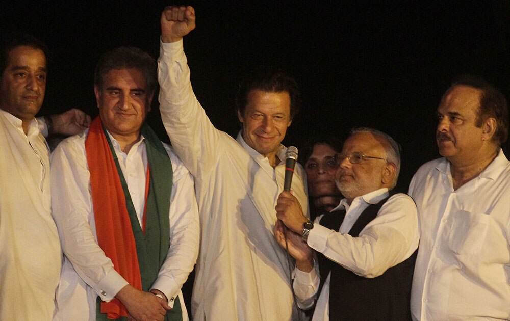 पाकिस्तान के लाहौर में अपने समर्थकों को संबोधित करते क्रिकेटर से राजनेता बने इमरान खान (बीच में)।