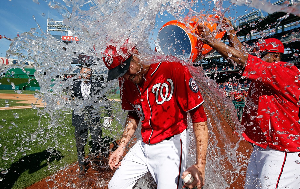 Washington Nationals starting pitcher Doug Fister, left, is doused with water by Michael Taylor after the first baseball game of a doubleheader at Nationals Park
