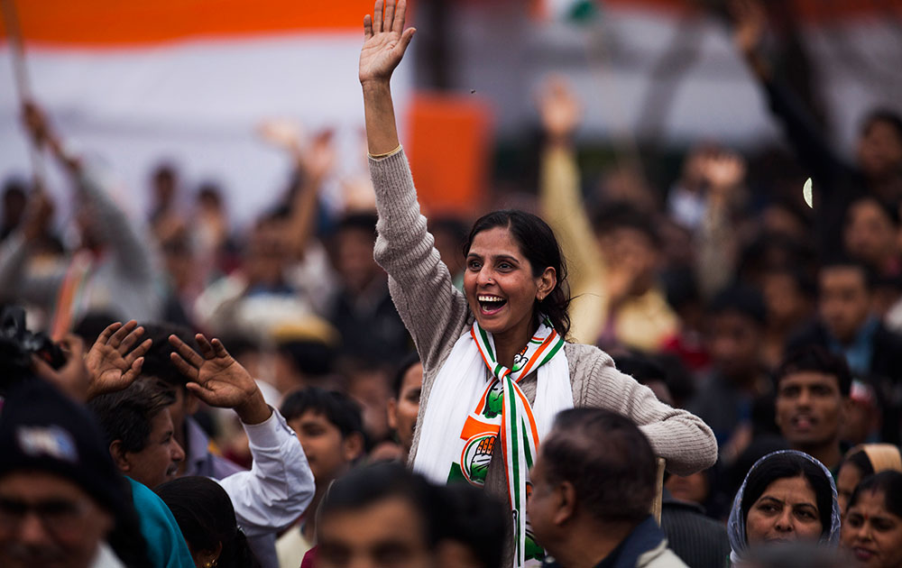 दिल्ली में कांग्रेस की एक चुनावी रैली के दौरान पार्टी अध्यक्ष सोनिया गांधी की मौजूदगी में हाथ हिलाता एक पार्टी समर्थक।