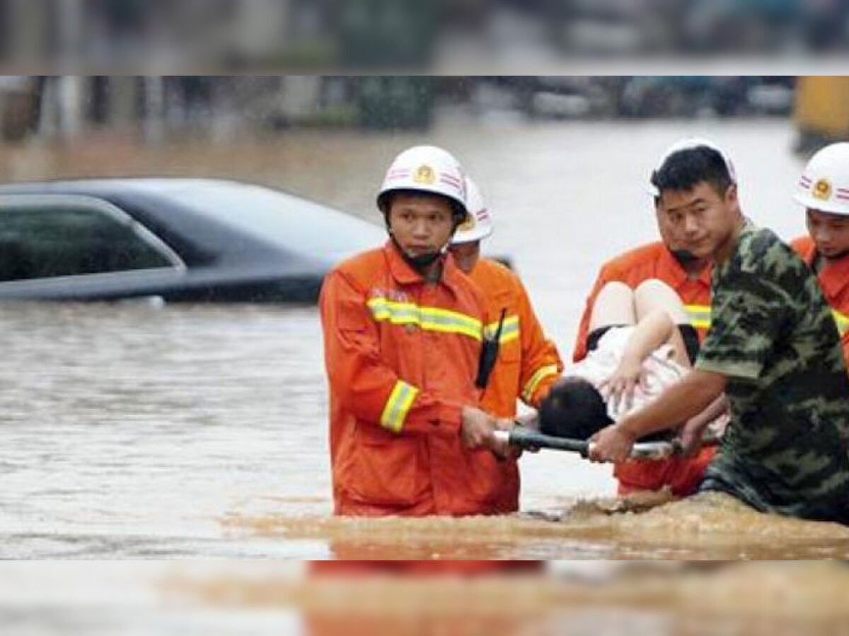 बाढ़ में फंसे लोगों को सुरक्षित निकालता बचाव कर्मी
