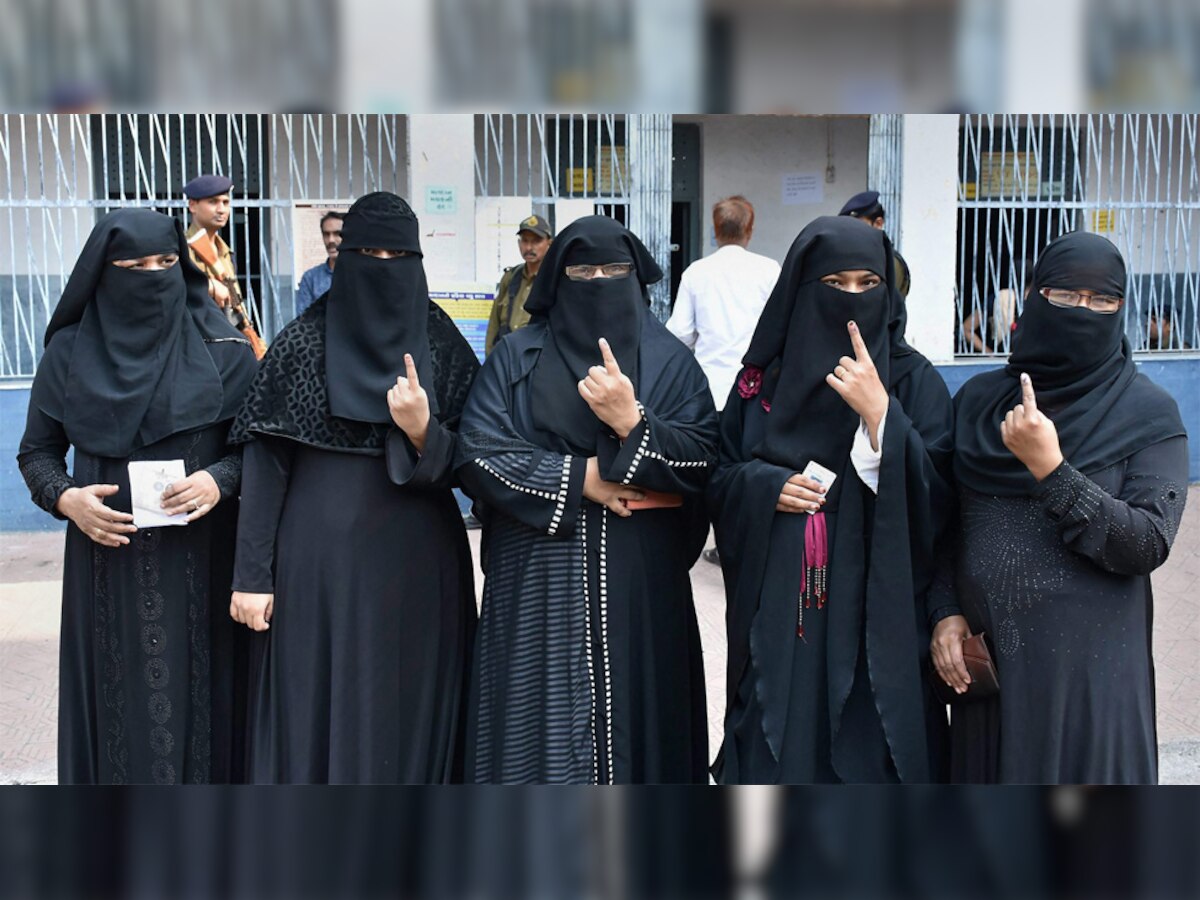 गुजरात में पहले चरण के चुनाव के दौरान सूरत में वोट डालने के बाद स्याही लगी अंगुली दिखातींं मुस्लिम महिलाएं. (PTI/9 Dec, 2017)