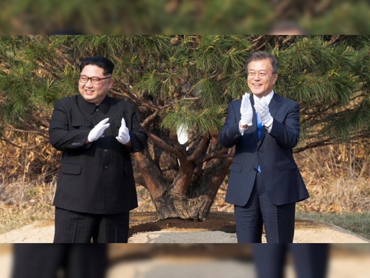 पुनमुनजोम में पौधारोपण के बाद उत्तर कोरियाई नेता किम जोंग उन और दक्षिण कोरियाई राष्ट्रपति मून जेई ताली बजाते हुए. (Reuters/27 April, 2018)