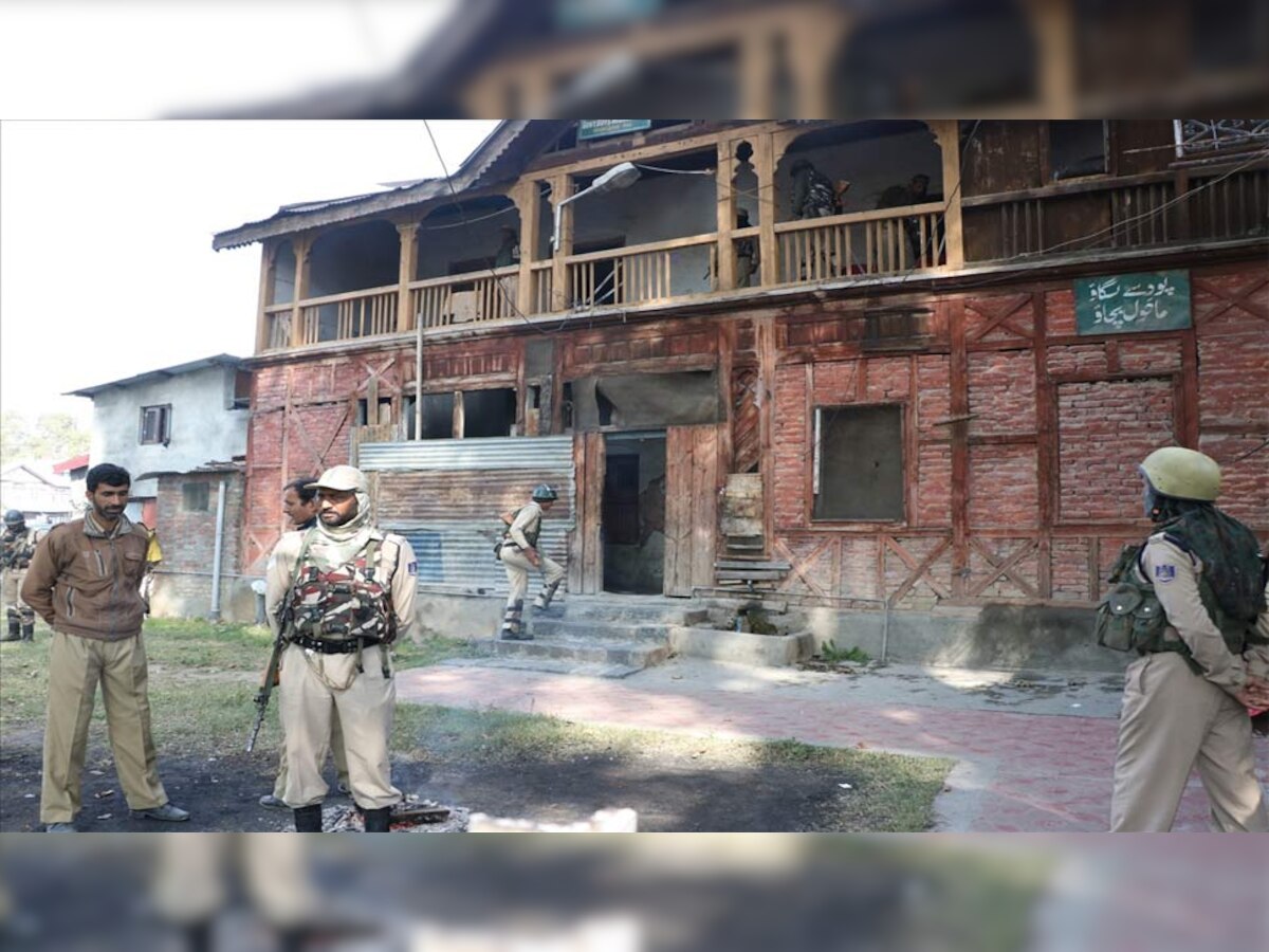 श्रीनगर में बुधवार (10 अक्टूबर को) एक पॉलिंग बूथ के बाहर खड़े सुरक्षाकर्मी. घाटी में दूसरे चरण का मतदान बुधवार सुबह छह बजे शुरू होकर शाम चार बजे तक चला.(फोटो साभार - IANS)