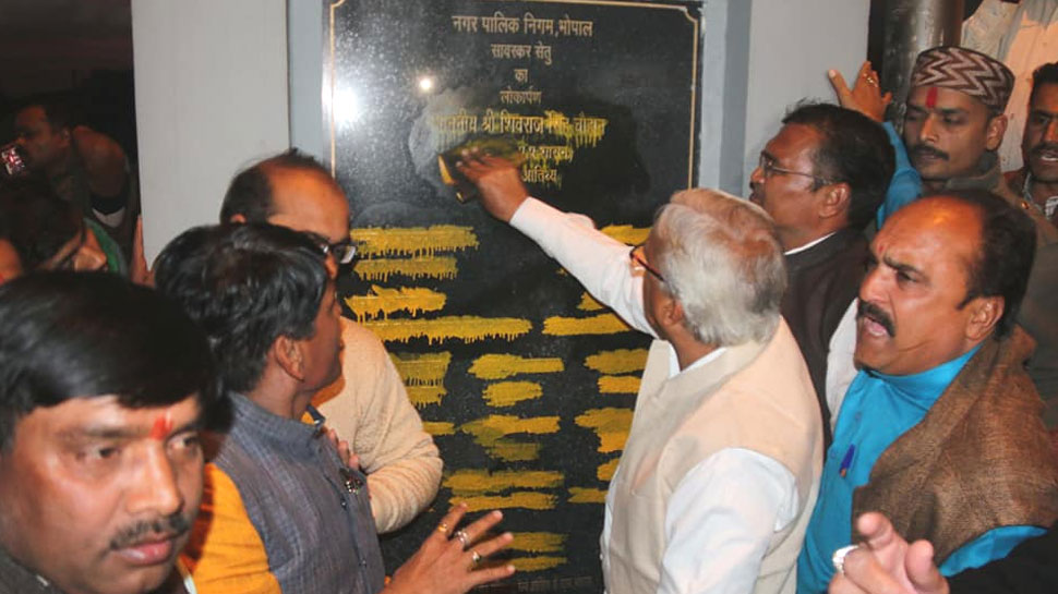 सीएम शिवराज सिंह चौहान के नाम से पेंट को हटाते बीजेपी के नेता. सीएम शिवराज सिंह चौहान के नाम से पेंट को हटाते बीजेपी के नेता.