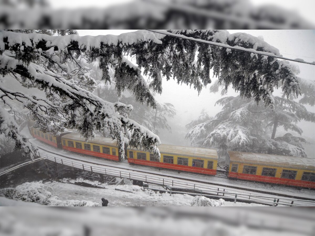 भारी बर्फबारी के बीच कालका-शिमला हेरीटेज रेल ट्रेक पर दौड़ती टॉय ट्रेन (फोटो साभार - PTI)