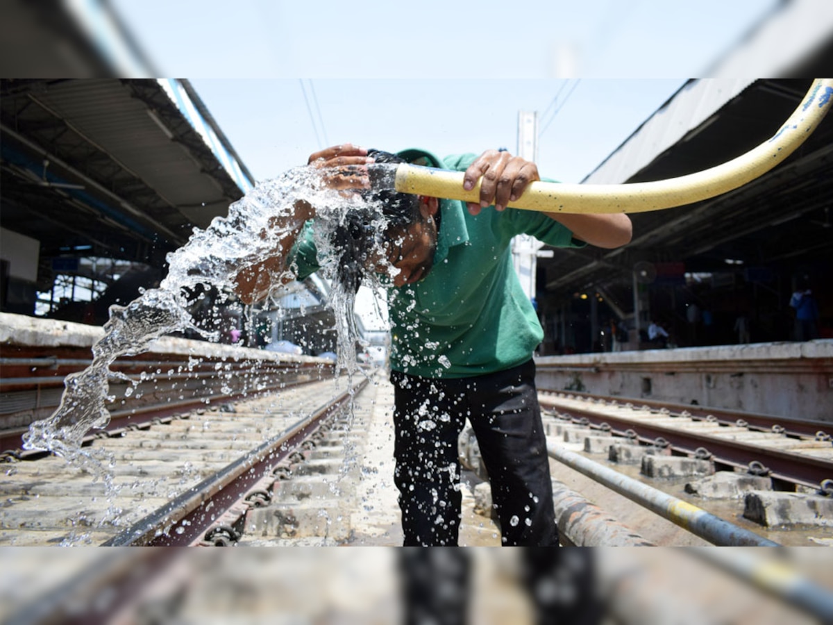 इलाहाबाद रेलवे स्टेशन पर गर्मी से निजात पाने के लिए पानी से अपना सिर ठंड़ा करता युवक. (फोटो-एएनआई)