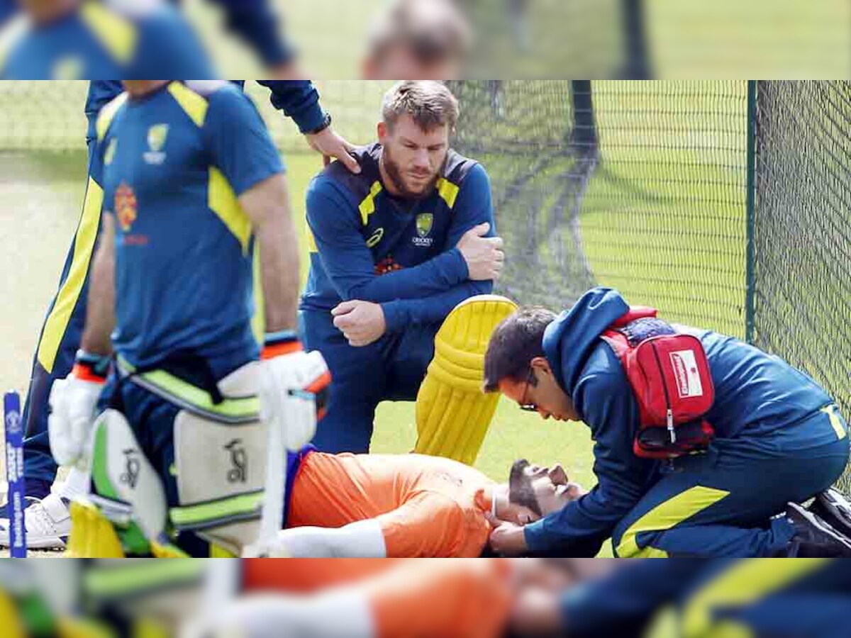 घायल गेंदबाज जयकिशन से बात करते डेविड वॉर्नर और साथी खिलाड़ी. (फोटो: IANS) 