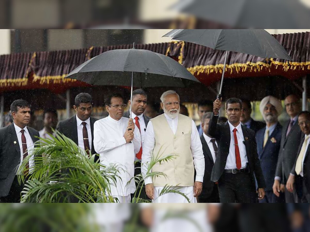 राष्ट्रपति आवास में मोदी का स्वागत किया गया. इस दौरान श्रीलंका के राष्ट्रपति मैत्रीपाला सिरिसेना हाथ में छाता लिए दिखाई दिए.(फोटो: रॉयटर्स)
