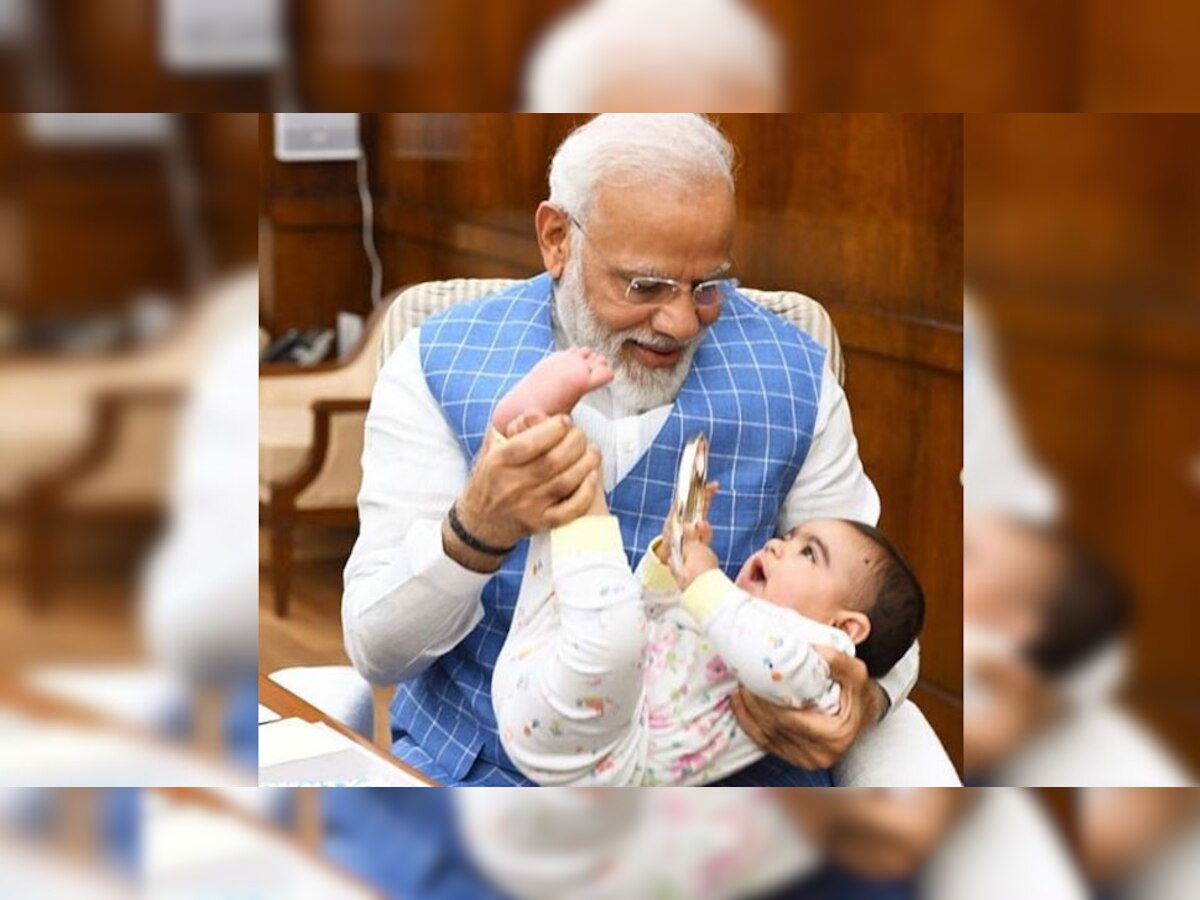 बच्चे के साथ खेलते पीएम मोदी. (फोटो साभार- narendramodi)