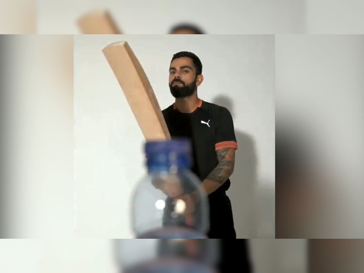 बल्ले से बॉटल का ढक्कन खोलते टीम इंडिया के कप्तान विराट कोहली. (फोटो साभार: Twitter/Videograb)