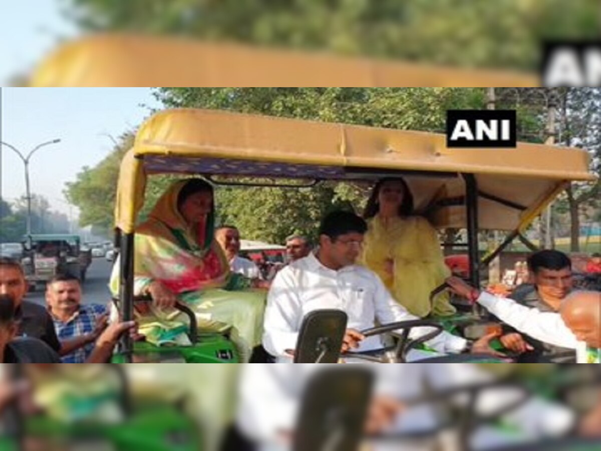 Dushyant Chautala arrive on a tractor, to cast their votes