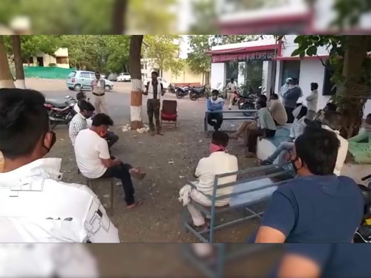 निसरपुर चौकी पर थाना इंचार्ज के साथ स्वैच्छिक कर्फ्यू को लेकर बैठक करते स्थानीय लोग.