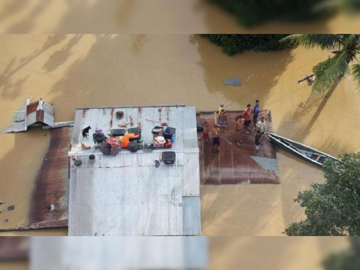 बाढ़ के कारण घर की छत पर बैठे काग्‍यान के निवासी (एएफपी) 