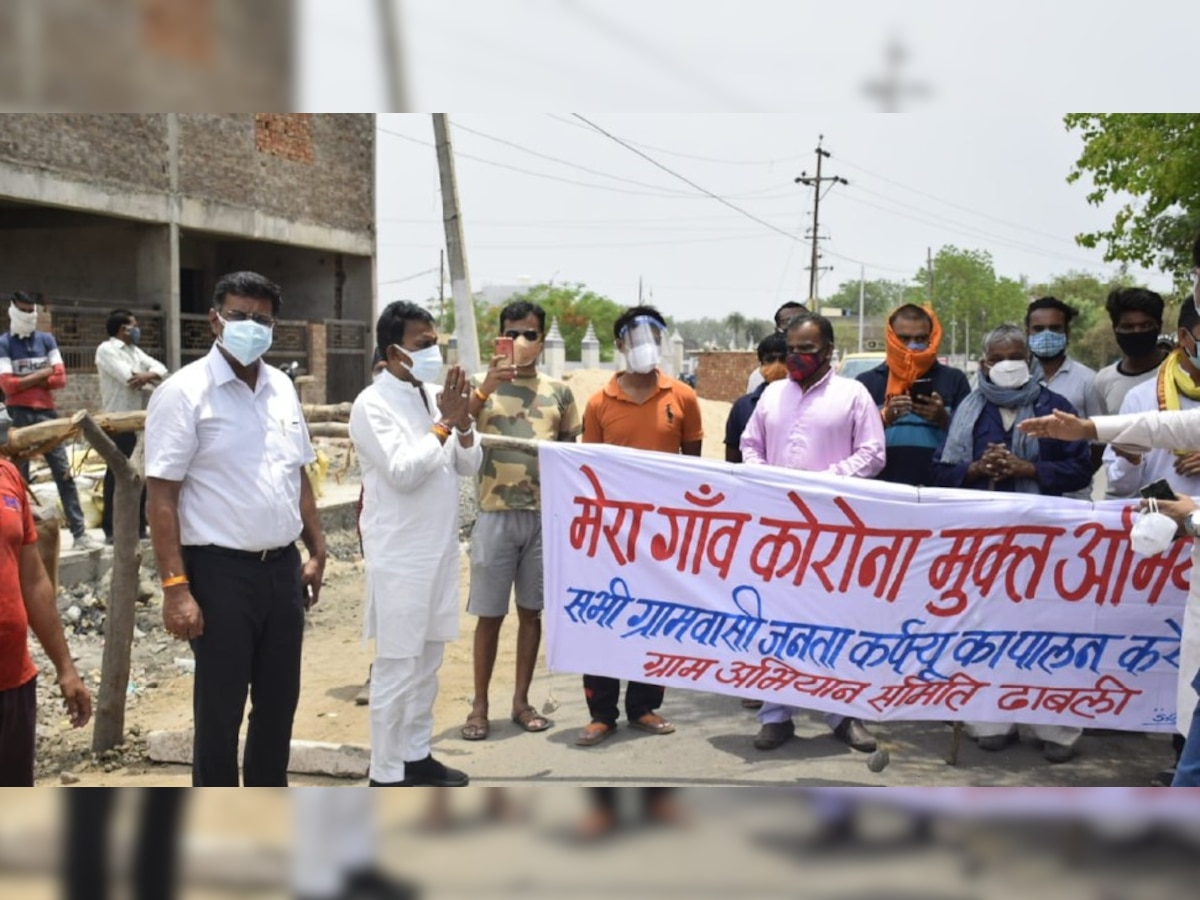 ढाबली गांव में बैरिकेड की दूसरी तरफ से ही ग्रामीणों से बात करते हुए मंत्री व DM. 