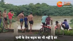 Video: उफनती नदी में जानलेवा स्टंट कर रहे हैं युवक, थोड़ी सी चूक से जा सकती है जान!