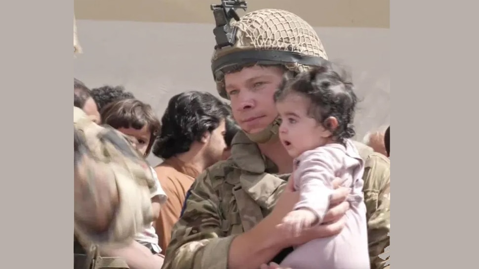 British soldier grips a child as parents try to get their child out of the country