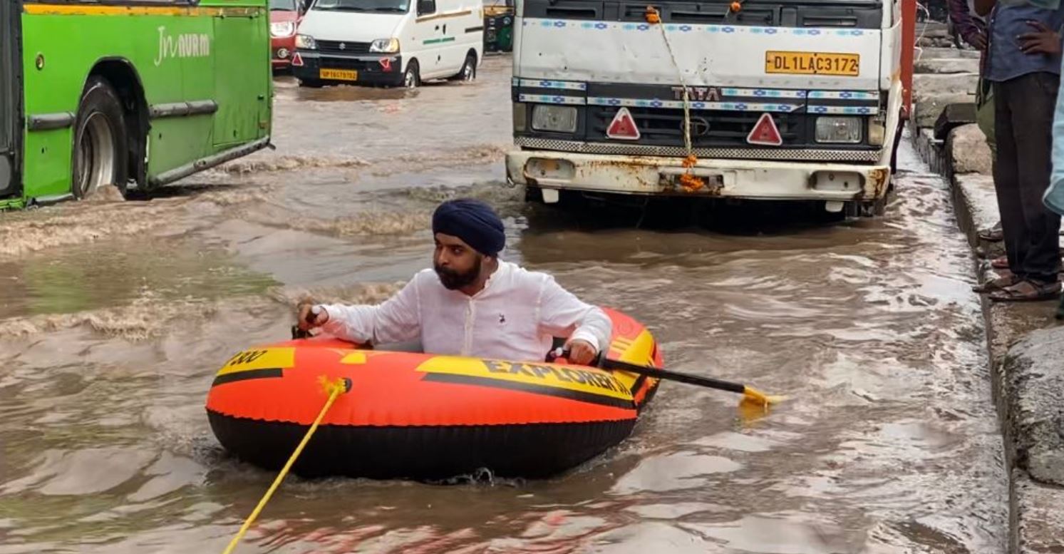 Video: पानी में डूबी सड़क पर BJP नेता ने चलाई नाव, कहा- केजरीवाल जी मौज कर दी