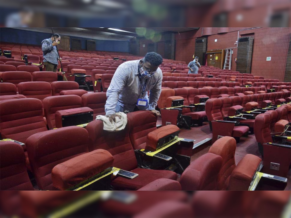 महाराष्ट्र के ठाणे में एक सिनेमाघर की सफाई करते मजदूर 