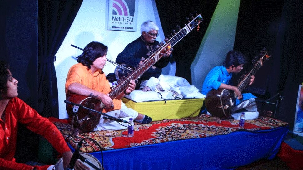 Three sitar players on a stage spread melodious notes with their fingers Jaipur एक मंच पर तीन