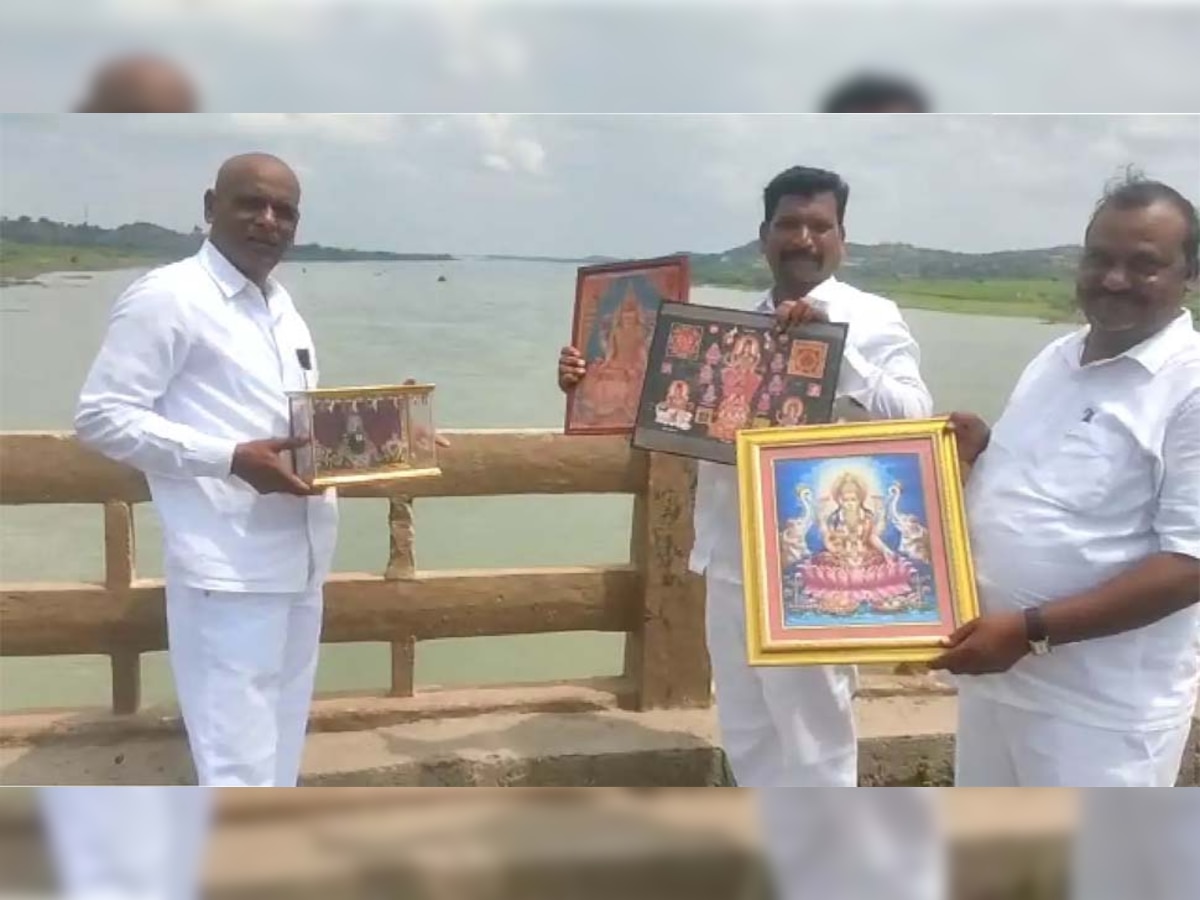 हिंदू देवताओं की तस्वीरें नदी में फेंकने से पहले उसे दिखाते हुए लोग 