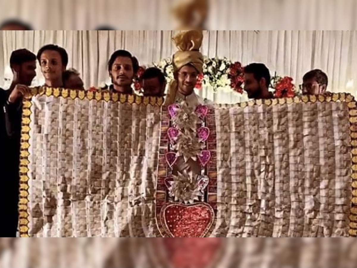 Wedding Photo Viral: दूल्हे ने पहन लिया इतना बड़ा नोटों का हार, कि शादी का पूरा स्टेज ही ढक लिया!