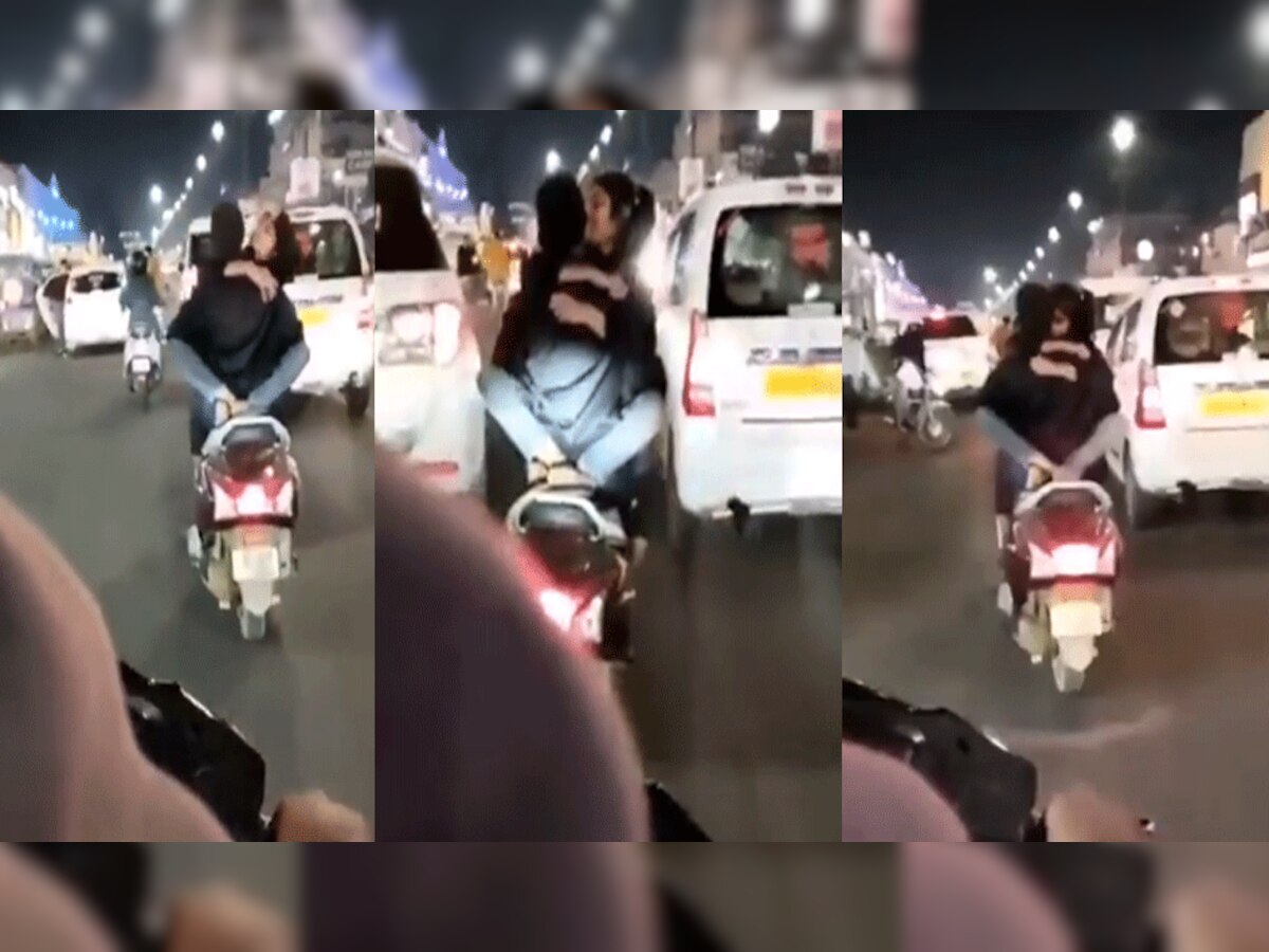 Viral Video : लखनऊ में चलती स्कूटी पर रोमांस करते कपल का वीडियो वायरल, लोग बोले बेशरम