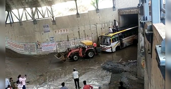 Sikar News The bus going from Neemkathana to Dabla got stuck in underpass water tractor pulled it out | Sikar News : नीमकाथाना से डाबला जा रही बस अंडरपास के पानी में फंसी, ट्रैक्टर ने खींचकर निकाली | Zee News Hindi