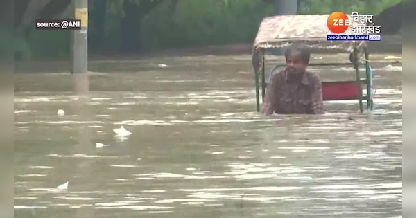 Delhi Flood in low lying areas due to rise in water level in Yamuna river man seen driving rickshaw near red fort | Delhi Flood: यमुना नदी में जल स्तर बढ़ने से निचले इलाके में आई बाढ़, पानी में रिक्शा चलाते दिखा शख्स | Zee News Hindi