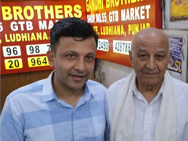 AI photo of retired postmaster who won a 6 crore lottery and his son