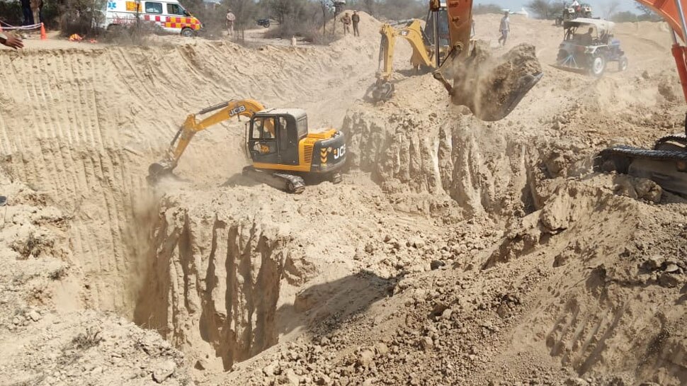 बच्चे को निकालने के लिए खुदाई करती हुईं जेसीबी