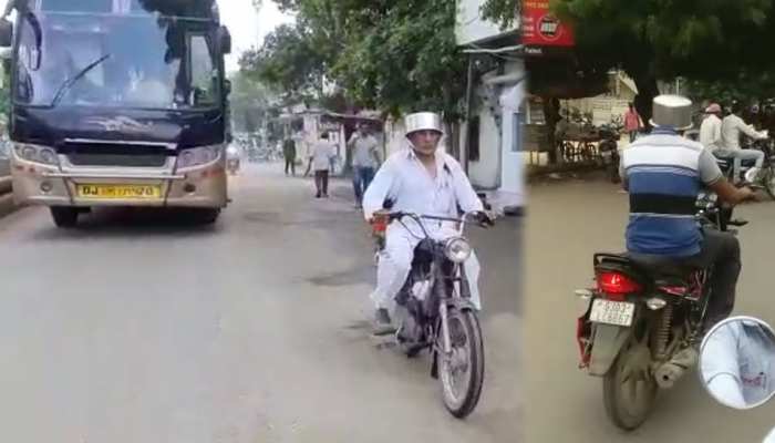 गुजरात: कम जुर्माने के बाद भी लोग नहीं मान रहे ट्रैफिक नियम, हेलमेट की जगह निकाला 'जुगाड़' गुजरात: कम जुर्माने के बाद भी लोग नहीं मान रहे ट्रैफिक नियम, हेलमेट की जगह निकाला 'जुगाड़'