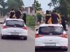  girls hanging from car 